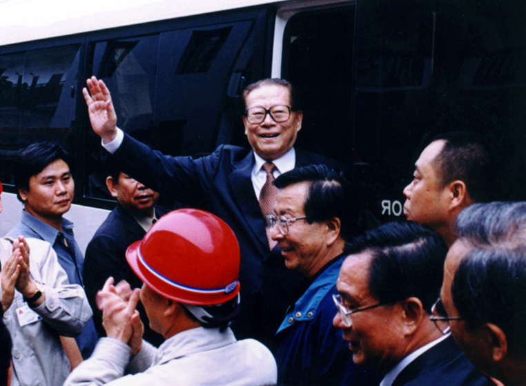 “同志們好！”“大家好！”邁出車門的江澤民向激動沸騰的西南鋁職工微笑地點頭，爽朗地問好，親切地揮手致意。（李影攝）