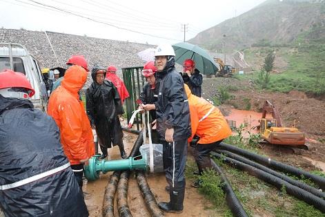 圖一為中州鋁業(yè)保障中心員工冒雨在現(xiàn)場(chǎng)搬運(yùn)潛水泵設(shè)備，以應(yīng)對(duì)未來(lái)幾天更加嚴(yán)峻的汛情。